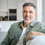 Man smiling while sitting on couch at home