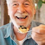 Man smiling while enjoying meal at home