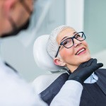 Woman with black glasses smiling at dentist