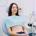 Woman sitting in dental chair and smiling