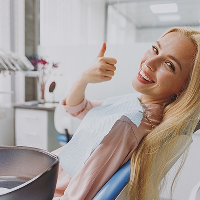 Blonde female dental patient giving a thumbs up